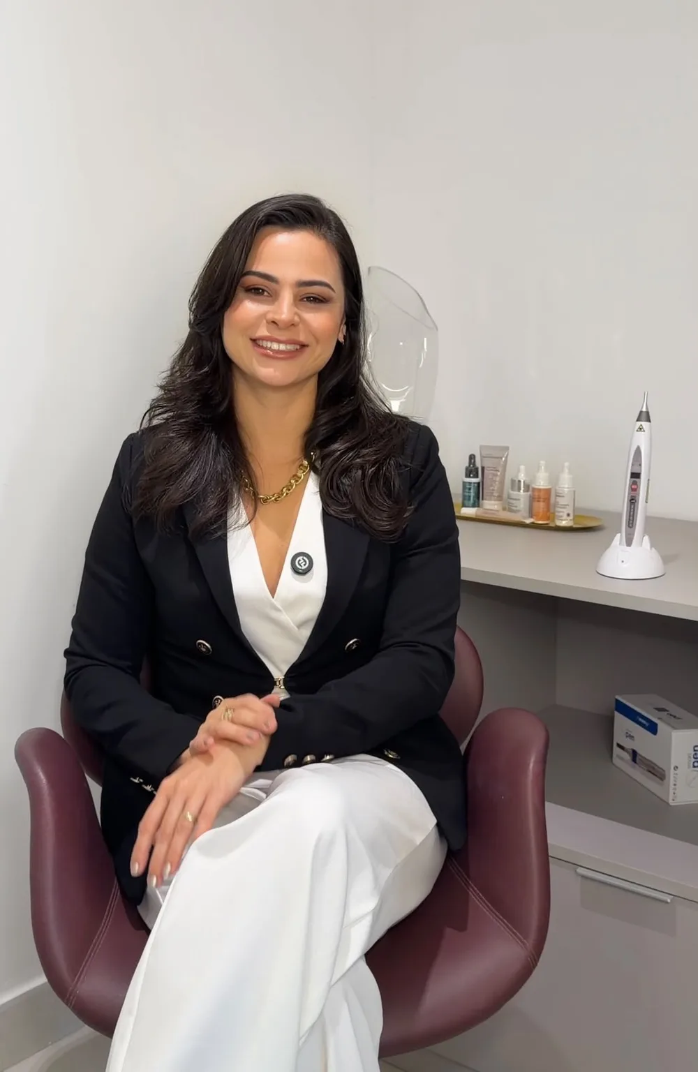 Dra. Vanessa Petrina, biomédica e farmacêutica esteta, sentada na sala de atendimento da Clínica Velleza em Natal